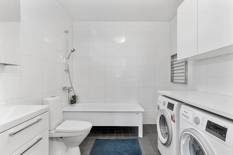 Helkaklat badrum med badkar och tvätt/tork maskin
