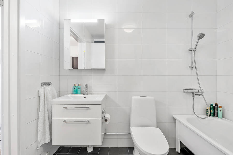 Helkaklat badrum med badkar och tvätt/tork maskin