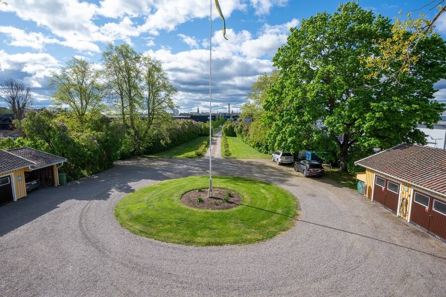 Infart med blommande rundel med flagstång