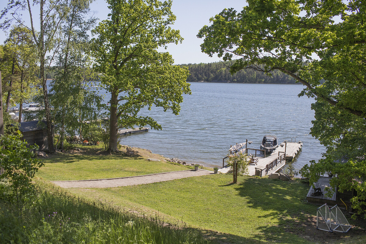 Sluttande tomt med grusgång ner till bryggan