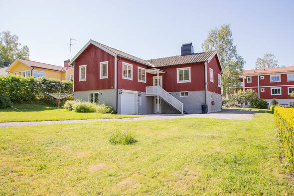 Tomt med gräsmatta och planteringar