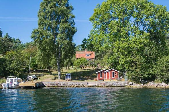 Brygga, båthus och charmigt hus på en södersluttning