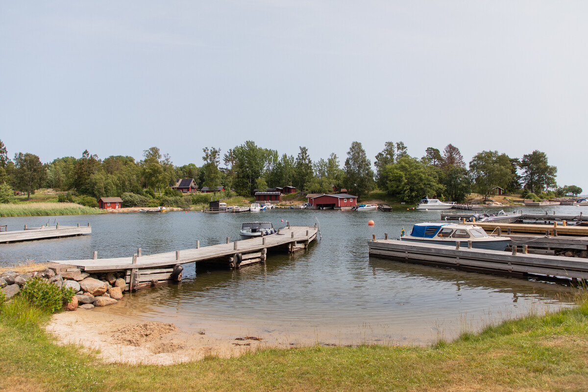Pittoreska Koholmaviken med sjöbodar och bryggor