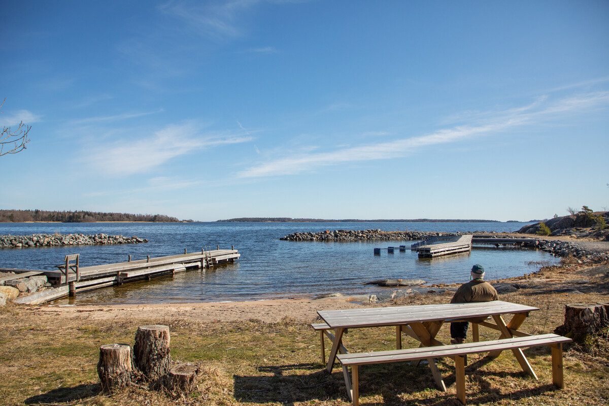 Sandstrand och brygganläggning med båtplatser